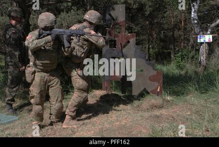 Us-Armee SPC. Julian Guila und SPC. Blake Myrick von Comanche Truppe, 1 Staffel, 2. Kavallerie Regiments, Battle Group Polen, Simulation der Zündung von einer überdachten Position, demonstriert das Wissen, das Sie aus der Anleitung der Polnischen Armee Lt's Golaszewski bei Sabre Streik 18 gelernt, statt an der Bemowo Piskie Training Area am 6. Juni 2018. Sabre Streik 18 ist der achte Iteration des langjährigen US-Army Europe - LED-kooperative Ausbildung übung, die Interoperabilität zwischen den Verbündeten und Partnern in der Region zu verbessern. (Michigan Army National Guard Stockfoto