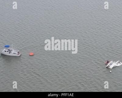 Ein guter Samariter unterstützt sechs Segler, nachdem ihr Boot in der Nähe von Reedy Island, New York, Juni 6, 2018 sank. Die Küstenwache wurde über Notruf gemeldet und mitgeteilt Partner Agenturen zu unterstützen, während gleichzeitig ein guter Samariter alle Nautiker, die das Tragen von Schwimmwesten waren gerettet. Us-Küstenwache Stockfoto