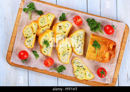 Gerösteten Fladenbrot Wraps mit Hackfleisch Huhn Fleisch und Käse in Scheiben geschnitten auf Schneidebrett mit frischer Petersilie und Tomaten gefüllt, close-up Stockfoto