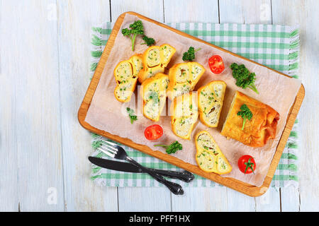 Gerösteten Fladenbrot Wraps mit Hackfleisch Huhn Fleisch und Käse in Scheiben geschnitten auf Schneidebrett mit frischer Petersilie und Tomaten gefüllt, close-up Stockfoto