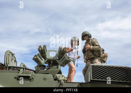 Ein Soldat aus der Regimental Support Squadron, 2d-Cavalry Regiment Posen mit einem litauischen Kind auf einem medizinische Evakuierung Stryker während einer Bekämpfung der Fähigkeiten in Kaunas, Litauen, 10. Juni 2018 an. 2CR, zusammen mit den Französischen, Deutschen und der litauischen Armee, sofern zeigt mehrere militärische Fahrzeuge für die Veranstaltung. Stockfoto