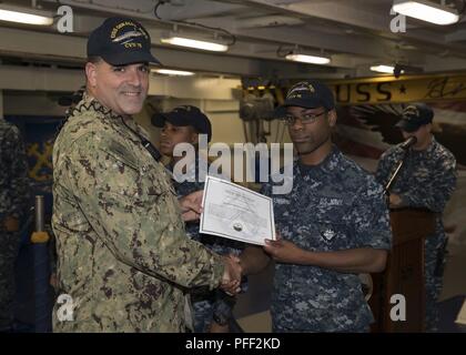 NORFOLK, Virginia (12. Juni 2018) - der bootsmann Mate Seemann Gregory McDaniel, von Houston, auf USS Gerald R. Ford's (CVN 78) deck Abteilung zugewiesen, heißt's Deck Abteilung blaue Jacke des Quartals von Lt.Cmdr. Edward Chinone, erste Ford's Leutnant, während einer Auszeichnungen bei Viertel Zeremonie in der Schiff-back. Stockfoto