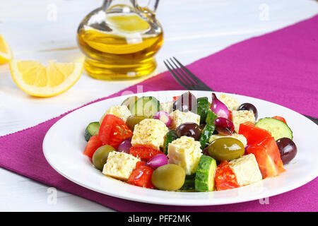 Frische und gesunde klassischer griechischer Salat mit Feta Käse, Gurke, Tomate, Oliven und roten Zwiebeln Zwiebeln, gewürzt mit trockenem Oregano bestreut und mit Oli Stockfoto