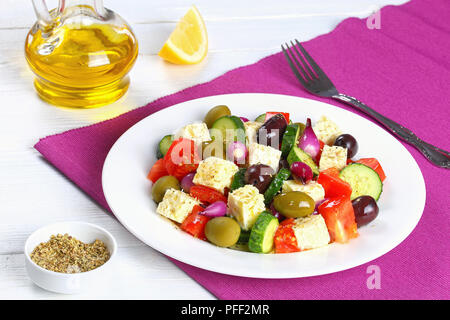 Frische und gesunde Griechischer Salat mit Feta Käse, Gurke, Tomate, Oliven und roten Zwiebeln Zwiebeln, gewürzt mit trockenem Oregano und bestreut mit Olivenöl o Stockfoto