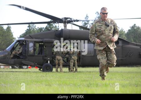 Ein Kader Mitglied weicht von der UH-60 Black Hawk Hubschrauber während des Betriebs um Veranstaltung in der U.S. Army Reserve 2018 besten Krieger Wettbewerb in Fort Bragg, North Carolina, 13. Juni 2018. Us-Armee Reservisten konkurrieren alle Tag und in die Nacht, sich auf jeden Fall während der 6-tägigen 2018 U.S. Army Reserve Bester Krieger Wettbewerb. Stockfoto