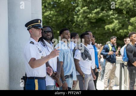 Us-Armee Sgt. 1. klasse James Jones (links), Sergeant, Veranstaltungen und Zeremonien, Arlington National Cemetery; Gespräche mit Detroit Lions Spieler LeGarrette Blount (Mitte) und Dwayne Washington (rechts) über den Wachwechsel Zeremonie am Grab des Unbekannten Soldaten auf dem Arlington National Cemetery, Arlington, Virginia, 12. Juni 2018. Die Löwen besucht Arlington National Cemetery in einem pädagogischen Mitarbeiter fahren, wo Sie mit Friedhof Vertreter, Field Operations sprach zu beteiligen und erhalten eine Führung durch die Gedenkstätte Amphitheater Anzeige Zimmer ab ANC Historiker. Stockfoto