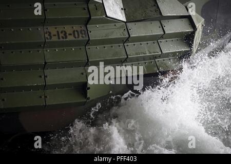 Meer Wasser spritzt auf einen Angriff Amphibienfahrzeug mit Bataillon Landung Team 3/1, 13 Marine Expeditionary Unit (MEU), während die Belastung im Meer von der Langley-Klasse dock Landung Schiff USS Rushmore (LSD 47), 13. Juni 2018. Das Essex Amphibious Ready Group (ARG) und 13 MEU leiten Composite Trainingsgerät Übung (COMPTUEX), die letzte Übung vor der bevorstehenden Bereitstellung. Diese Übung überprüft die Fähigkeit der ARG/MEU team Anpassen und Ausführen Missionen in immer neuen, unbekannten Umgebungen. Nach Abschluss der COMPTUEX, dem 13. MEU und Essex ARG zertifiziert werden. Stockfoto