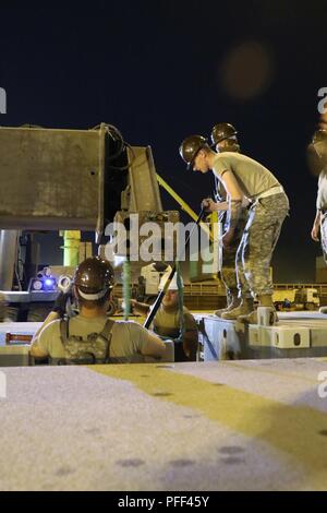 SHUAIBA PORT, Kuwait-SPC. Salbei Gregory arbeitet mit anderen Mitgliedern der 331 Transport Unternehmen, auf der Grundlage von Joint Base Langley - Eustis, Virginia, zusammen mit der Internationalen Organisation für Normung (ISOPAK) zu einem 'String', die dann in das Wasser am Shuaiba Port, 13. Juni vorgelegt werden. Die ISOPAKs sind Komponenten des Roll-on/Roll-off-Entlastung Werk gebaut, um die Logistik-über-die-Shore Mission geschieht während der nautischen Horizont Übung der Armee 2018 zu unterstützen. Nautische Horizont 2018 ist eine 2-stufige U.S. Army Central Stockfoto