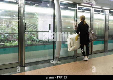 Von Paris, an der Wand - die Frau lehnte sich auf der Plattform an der Wand und sah den Zug in den Bahnhof Gare de Lyon in Paris, Frankreich, Europa. Stockfoto