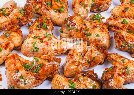 Raw saftige Chicken Wings mariniert mit Honig, Sojasauce, gewürzen bestreut mit fein gehackte Petersilie auf weißem Hintergrund, vorbereitet für Braten, asiatische Stockfoto