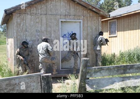 Soldaten aus Kansas Nationalgarde und Finden kick Zugang zu einem Gebäude beim Training auf die militärischen Operationen in urbanem Gelände (mout) Ausbildung Lane während des goldenen Coyote Übung, West Camp Rapid, Rapid City, S.D., 13. Juni 2018 zu gewinnen. Fähigkeiten während der Goldenen Coyote training Übung gelernt gehören Team Building, Medizin, Land, Navigation, Konvoi, militärische Operationen in urbanem Gelände, Base Defense operations, Kraft, Schutz und Einheit mission Aufgaben. Stockfoto