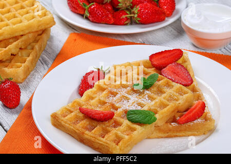 Belgische Waffeln mit Erdbeeren und Puderzucker auf einer Platte Stockfoto