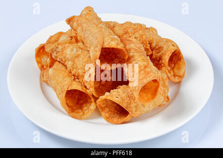 Hausgemachte frittierte Cannoli vorbereitet für die Füllung auf weiße Platte auf der Küchenarbeitsplatte, Ansicht von oben, close-up Stockfoto