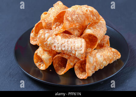 Leckere hausgemachte Frittierte cannoli zum Befüllen mit Ricotta Käse auf schwarze Platte auf dunklem Schiefer Fach vorbereitet, authentische Rezept, Ansicht von oben, c Stockfoto