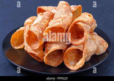 Leckere hausgemachte Frittierte cannoli zum Befüllen mit Ricotta Käse auf schwarze Platte auf dunklem Schiefer Fach vorbereitet, authentische klassisches Rezept, horizontal Stockfoto