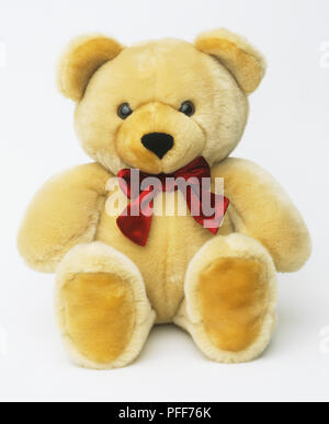 Gelbe Teddybär mit roter Schleife binden, aus der Nähe. Stockfoto