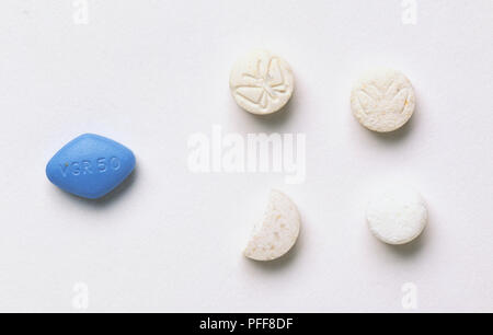 Vier Tabletten, drei Weiße und Rundschreiben, eine gebrochene, einem blauen, schmetterling Bild auf zwei Stockfoto