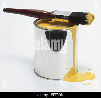 Edelstahl lack Topf mit gelber Farbe mit Pinsel auf die Oberseite. Stockfoto