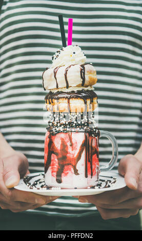 Mann hält kalten Erdbeere Donut freakshake in Mason jar Stockfoto