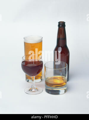 Glas Rotwein, ein Glas Whisky, Bier und eine Flasche Bier Stockfoto