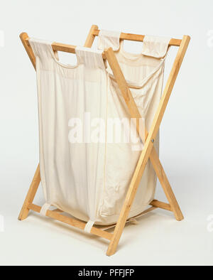 Klappbarer Wäschekorb mit leichten Rahmen aus Holz und weiche, calico Baumwolltasche, schräg von der Seite. Stockfoto