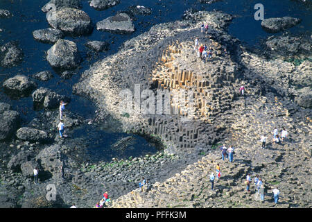 Nordirland, County Antrim, Giant's Causeway, Touristen zu Fuß auf Basaltsäulen, hohe Betrachtungswinkel Stockfoto