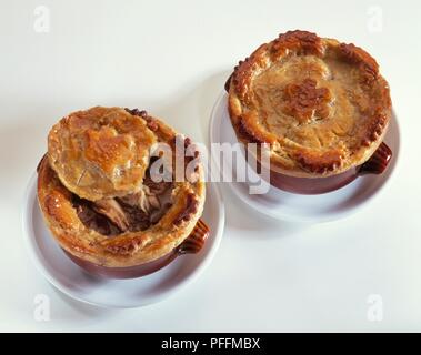 Zwei Steaks und Niere Torten in kleine braune Gerichte, eine mit der Spitze aus, Nahaufnahme, Ansicht von oben Stockfoto