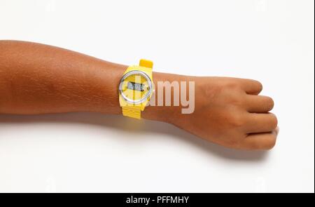 Gelb digitale Uhr auf Girl's Arm, close-up Stockfoto