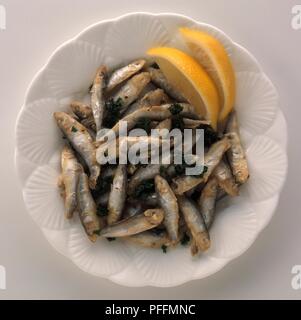 Platte der Friture de la Loire, frittierte whitebait mit Zitronenscheiben serviert, Ansicht von oben Stockfoto