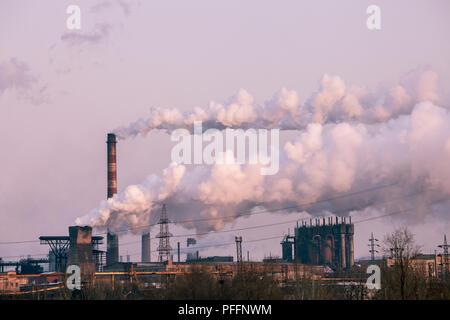 Schornsteine in einer Fabrik emitting Dampf, Smog und Luftverschmutzung. Stockfoto