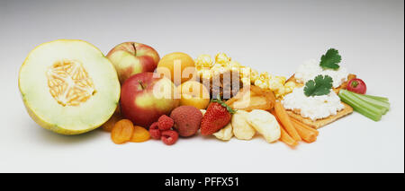 Beispiele für gesunde Snacks wie leicht gesalzen, knallte, Popcorn, frisches Obst, getrocknetes Obst, rohes Gemüse und Vollkorn Cracker Stockfoto