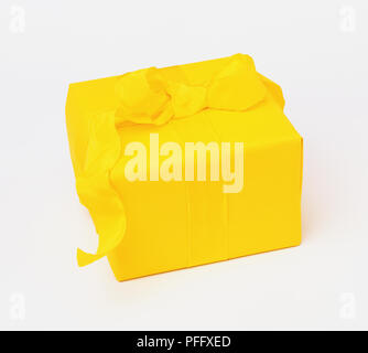 Quadratische Geschenk mit gelbem Papier- und gelbe Band umwickelt Stockfoto