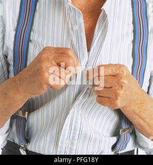 Ältere Mann in geschweiften Klammern, sein Hemd zuzuknöpfen. Stockfoto