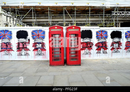 Rote Telefonzellen und Graffiti Wachposten (von Nathan Bowen) in St Martin's Place, London, England, UK. Stockfoto