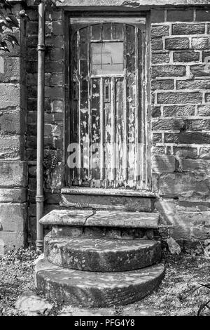 Schwarz-weiß Fotografie alte Tür und Schritte in der Badewanne, Gärten, Bakewell, Fluss Wye, Derbyshire Dales im Peak District, England, Vereinigtes Königreich, Stockfoto