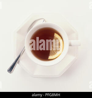 Tasse Lapsang Souchong Tee mit zitronenscheibe, Untertasse, Löffel, Ansicht von oben Stockfoto