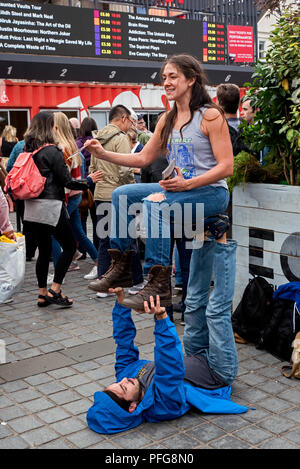 Eine junge Frau mit einem neuartigen Weg, um die Aufmerksamkeit, als sie eine Show im Edinburgh Fringe Festival fördert auf dem Damm. Stockfoto