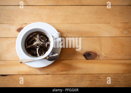 Tasse schwarzen Eiskaffee auf hölzernen Tisch. Eis Kaffee Draufsicht mit kopieren. Sommer Erfrischung. Stockfoto