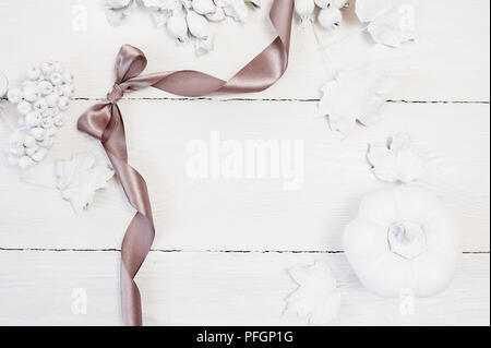 Mockup Herbst graue Band, Weiß Kürbis, Beeren und Blätter auf einem Holz- Hintergrund. Grußkarte zum Erntedankfest im rustikalen Stil mit Platz für Ihren Text. Flach. Ansicht von oben Stockfoto