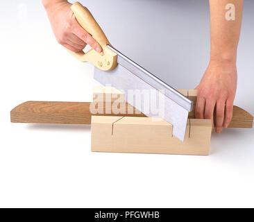 Hände sägen Stück Holz in der Hälfte mit zapfensäge und Mitre Block (Rahmen) Stockfoto