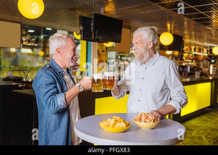 Positive freudige ältere Männer jubeln mit Bier Stockfoto