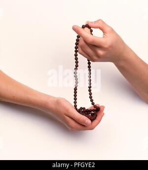Hände halten Der gebetsperlen Stockfoto
