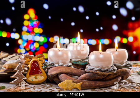 Adventskranz mit brennenden Kerzen vor dem Weihnachtsbaum Stockfoto