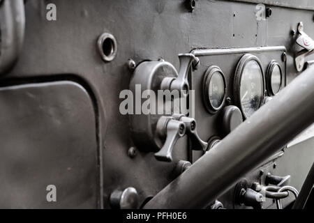 Nahaufnahme, flacher Fokus eines restaurierten Koreakriegs US Army Jeep mit Lenksäule, Zifferblättern und Schaltgetriebe. In olivfarbenem, düstem Lack. Stockfoto