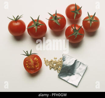 Solanum Lycopersicum, fünf und eine halbe rote Tomaten und Tomaten samen Verschütten von Silber Paket, Ansicht von oben Stockfoto