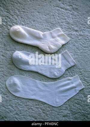 Drei weiße Söckchen für Sport Schuhe auf konkreten Hintergrund Stockfoto