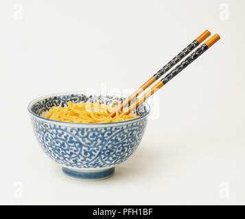 Orientalische Schale mit Nudeln und der hölzernen Eßstäbchen gefüllt Stockfoto