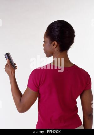 Frau stand halten, Diktiergerät, zurück zu Kamera Stockfoto