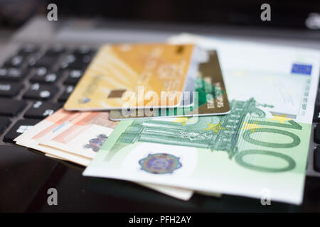 In der Nähe von Euro-Banknoten und Kreditkarten auf Laptop Tastatur Stockfoto