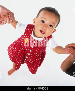 Baby Mädchen in einem roten Polka Dot dress up Schauen und Lächeln beim Laufen, hohe Betrachtungswinkel Stockfoto